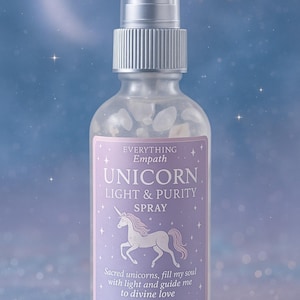 May include: A clear glass spray bottle with a silver cap and a purple label. The label reads "Unicorn Light & Purity Spray" with a unicorn illustration. The background is a blue gradient with stars.