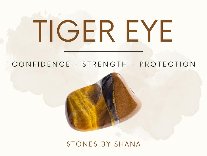 May include: Tiger Eye stone with brown, gold, and black stripes. The stone is a tumbled, smooth, polished shape. The text "TIGER EYE" is above the stone, and the text "CONFIDENCE - STRENGTH - PROTECTION" is below the stone. The text "STONES BY SHANA" is at the bottom of the image.