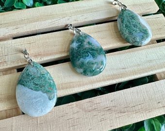 May include: Three green and white agate stone pendants with silver bail loops. The stones are teardrop shaped and have a natural, organic pattern.