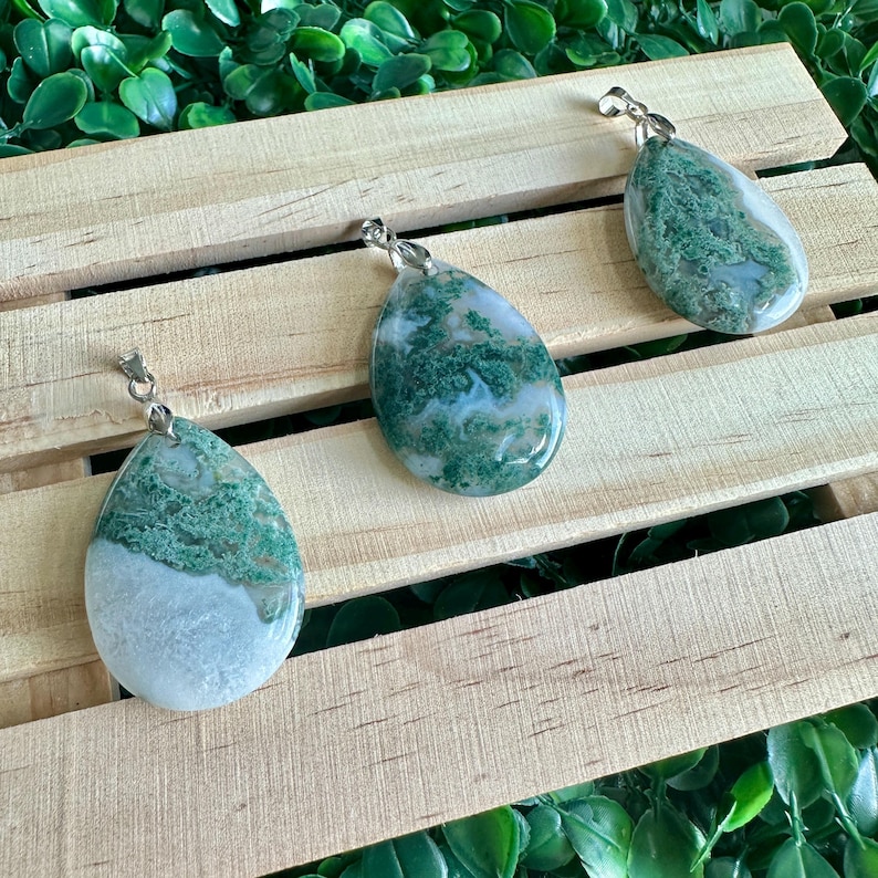 May include: Three green and white agate stone pendants with silver bail loops. The stones are teardrop shaped and have a natural, organic pattern.