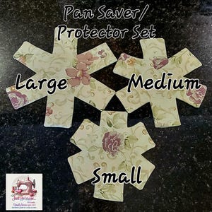 May include: A set of three floral pan protectors in different sizes: large, medium, and small. The protectors have a cream background with a pattern of purple flowers and green leaves. The text "Pan Saver/ Protector Set" is at the top.