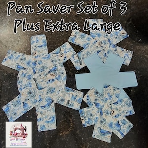 Pode incluir: Um conjunto de protetores de panelas com um design floral e de pássaros. O tecido apresenta pássaros azuis, borboletas e flores em um fundo branco. O conjunto inclui três protetores estampados e um protetor azul claro liso. O texto "Pan Saver Set of 3 Plus Extra Large" está no topo.