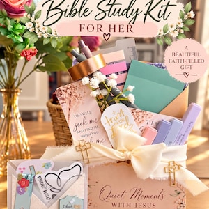 May include: A Bible Study Kit for Her gift set featuring a box labeled Quiet Moments with Jesus, decorated with floral patterns. It includes pens, sticky notes, a ruler, bookmarks with text like You will seek me and find me, and cross-shaped paper clips. The set is tied with a cream ribbon.