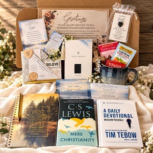 May include: A gift box containing a Holy Bible, a blue ceramic mug, tea packets, a small heart-shaped stone in a pouch, a wooden cross, and three books titled Trust in the Lord, Mere Christianity by C.S. Lewis, and A Daily Devotional by Tim Tebow.