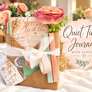 May include: A brown paper-wrapped journal set titled Time With Him, adorned with pink and peach artificial flowers, a white ribbon, cross-shaped paper clips, pens, washi tape, and a tag reading If the stars were made to worship so will I.