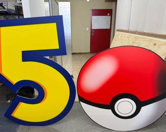 May include: A large, yellow number five with a blue border stands next to a red and white Pokeball. The number has an orange outline. The Pokeball is round with a black stripe and white circle.