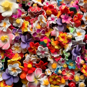 May include: A vibrant assortment of colorful artificial flowers in various sizes and shapes. The flowers are predominantly white, yellow, pink, red, and purple, creating a visually appealing and cheerful display. The arrangement is dense, with the flowers closely packed together.