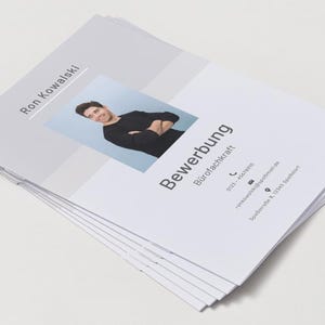 Puede incluir: Una pila de documentos de solicitud de empleo blancos con el nombre Ron Kowalski, el t&iacute;tulo Bewerbung B&uuml;rofachkraft, una foto de una persona con camisa negra de manga larga y datos de contacto que incluyen tel&eacute;fono, correo electr&oacute;nico y direcci&oacute;n.