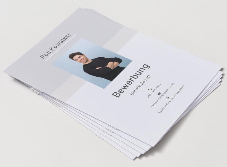 Puede incluir: Una pila de documentos de solicitud de empleo blancos con el nombre Ron Kowalski, el t&iacute;tulo Bewerbung B&uuml;rofachkraft, una foto de una persona con camisa negra de manga larga y datos de contacto que incluyen tel&eacute;fono, correo electr&oacute;nico y direcci&oacute;n.