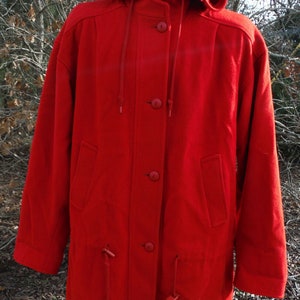 May include: A vibrant red hooded coat with a button-up front and two front pockets. The coat features a drawstring hood and drawstrings at the waist. This outerwear garment is suitable for cold weather.
