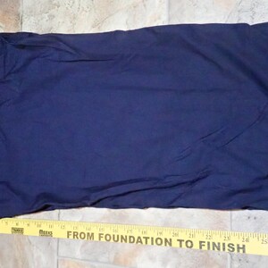 May include: A dark blue pair of pants with a yellow measuring tape at the bottom. The tape reads "From Foundation to Finish".
