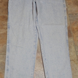 Puede incluir: Vaqueros de mezclilla azul claro lavados con ácido con corte recto.