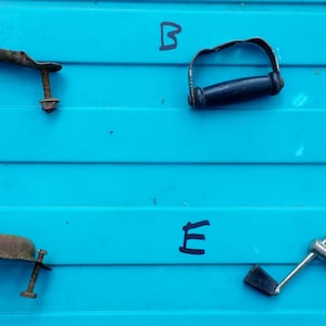May include: Five different metal handles on a blue background. The handles are labelled A, B, C, D, and E.