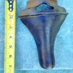 May include: A blue metal bicycle seat post with a decorative design. The seat post is approximately 8 inches long.