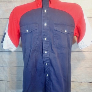 May include: A blue, red, and white short-sleeved button-up shirt with two chest pockets.