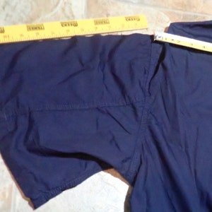 May include: A navy blue short-sleeved shirt with a seam down the center of the sleeve.