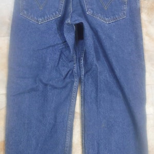 May include: A pair of blue denim jeans with a red Levi's patch on the back pocket.