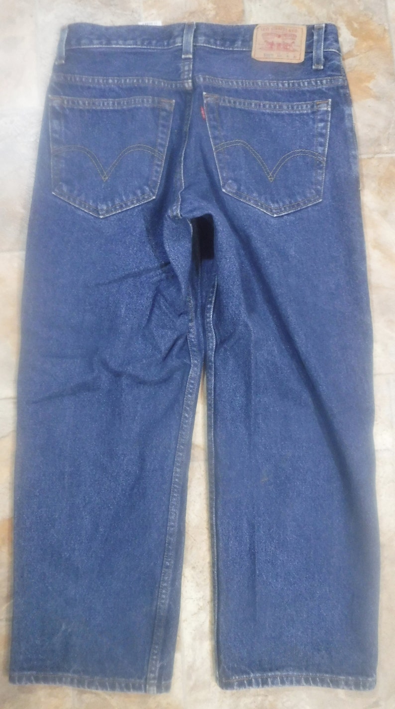 May include: A pair of blue denim jeans with a red Levi's patch on the back pocket.