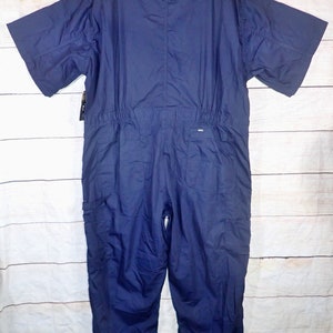 May include: A navy blue short-sleeved jumpsuit with a zipper closure and pockets. The jumpsuit has a drawstring at the waist.
