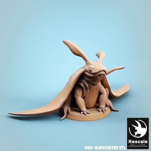 Puede incluir: Una figura de criatura estilizada de color beige con orejas grandes y una capa fluida. La figura está sobre una base circular y tiene el texto "PRE-SUPPORTED STL" en la parte inferior. El logotipo de Rescale Miniatures está en la esquina inferior derecha.