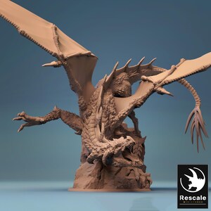 May include: A detailed, tan-coloured dragon figurine with outstretched wings and an open mouth, revealing sharp teeth. The dragon is perched on a rocky base, with intricate scales and textures. The Rescale Miniatures logo is in the bottom right corner.