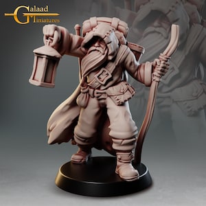 Puede incluir: Figura en miniatura detallada de un personaje con túnica y barba larga, sosteniendo una linterna y un bastón. La figura tiene una mochila y bolsas, y está de pie sobre una base negra. La figura es de color marrón claro.
