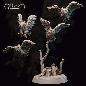 Puede incluir: Colección de figuras de búhos detalladas en varias poses, algunas con alas extendidas, otras posadas en una rama de árbol y un tocón esculpidos. Las figuras son de color claro y neutro, sobre un fondo oscuro, con la palabra "GALAAD" en la esquina superior izquierda.