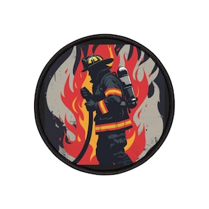 Può includere: Una toppa rotonda con un vigile del fuoco in silhouette in piedi davanti a una grande fiamma arancione e gialla. Il vigile del fuoco indossa un casco, una giacca nera con strisce gialle e un serbatoio nero sulla schiena. Lo sfondo è grigio usurato.