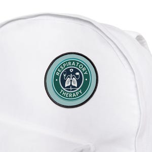 May include: A white backpack with a circular patch that reads "Respiratory Therapy." The patch has a teal and dark green border, with a stethoscope, lungs, and heart graphic in the center. The text is in white.