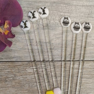 以下が含まれることがあります： カラフルなガラスビーズがついたガラス製の攪拌棒8本セット。ガラスビーズは青、黄、ピンク、白です。棒は、黒と白のウサギと卵の入ったバスケットの絵柄で飾られています。