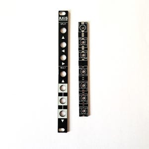 May include: Two black metal panels with white text and graphics. The panel on the left has the text "AXIS MODULAR" and "SPLIT" and "MULT". The panel on the right has the text "S" and has a series of small circles and lines.