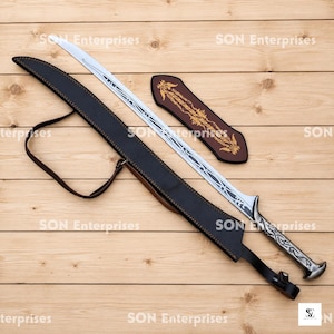 May include: A curved silver sword with intricate black etched patterns along the blade and a textured handle. The sword is accompanied by a black leather scabbard with a strap and a separate brown leather piece featuring gold decorative detailing.