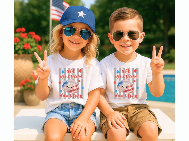 May include: Two children wearing white t-shirts with the text "all american dumpling" and a graphic of a dumpling decorated with the American flag. The girl wears a blue cap and sunglasses, and the boy wears sunglasses. They are smiling and making peace signs.