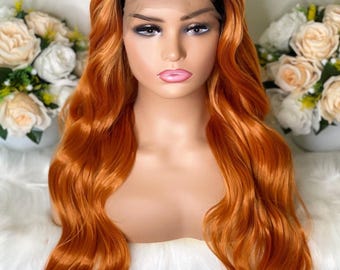 May include: A long, wavy synthetic wig featuring a dark brown root transition that blends into a vibrant copper orange color. The wig is styled with a center part and includes a sheer lace front panel along the hairline for a natural appearance.