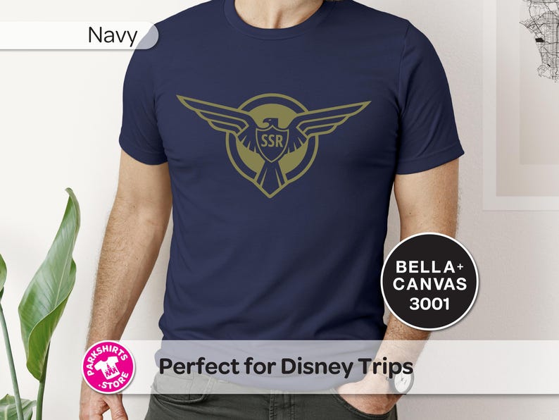 May include: Navy blue t-shirt with a gold emblem of an eagle and the letters "SSR". The shirt is a Bella+Canvas 3001 model. The t-shirt is a solid navy blue colour.