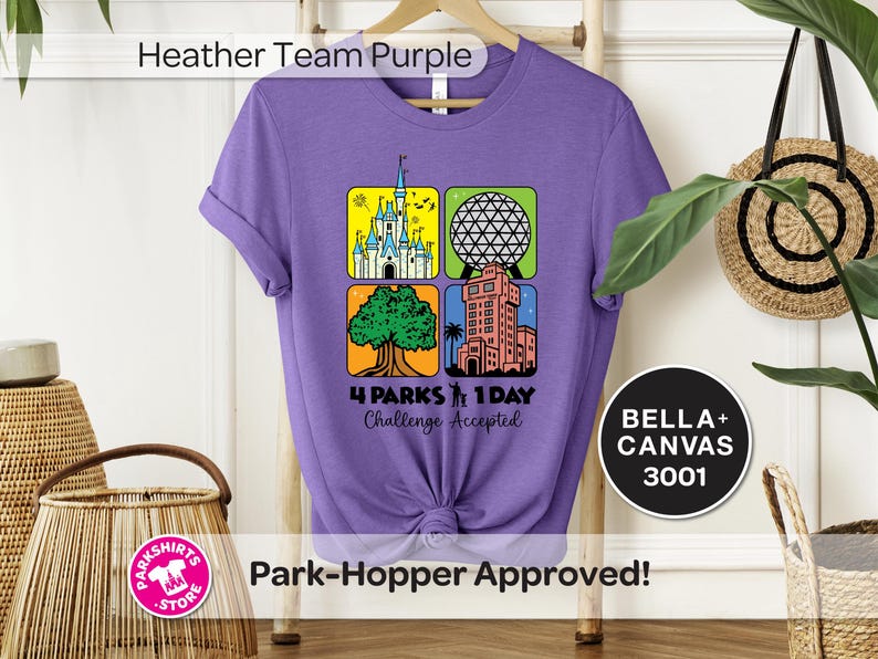 Puede incluir: Una camiseta morada con un gr&aacute;fico que presenta cuatro iconos de parques tem&aacute;ticos. El dise&ntilde;o incluye un castillo, una esfera geod&eacute;sica, un &aacute;rbol y una torre. El texto dice "4 Parks 1 Day Challenge Accepted". La camiseta es una Bella+Canvas 3001.