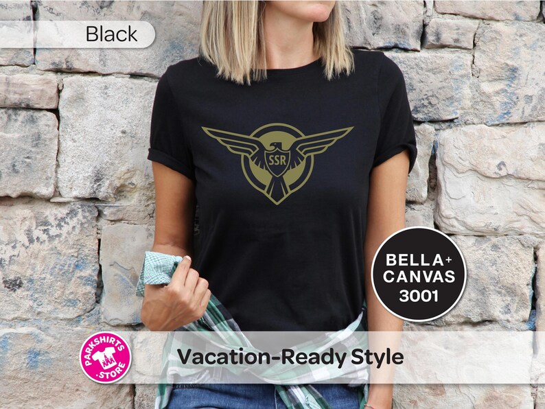 May include: Black t-shirt with a gold emblem featuring an eagle and the letters "SSR". The shirt is labelled "BELLA + CANVAS 3001" and "Vacation-Ready Style". The word "Black" is also displayed.
