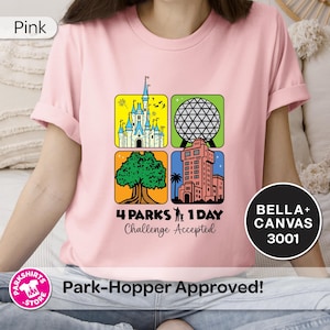 Puede incluir: Camiseta rosa claro con un gr&aacute;fico colorido que presenta cuatro iconos de parques tem&aacute;ticos. El dise&ntilde;o incluye un castillo, una esfera geod&eacute;sica, un &aacute;rbol y una torre, con el texto "4 Parks 1 Day Challenge Accepted". Hecha de Bella+Canvas 3001.