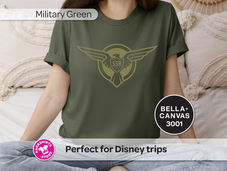 May include: Military green t-shirt with a gold eagle emblem and the letters "SSR" inside a shield. The shirt also features the text "BELLA + CANVAS 3001".