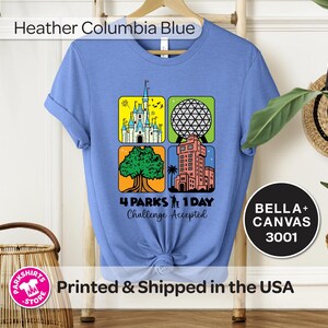Puede incluir: Camiseta azul Heather Columbia con un gr&aacute;fico que presenta cuatro iconos de parques tem&aacute;ticos. La camiseta tiene el texto "4 Parks 1 Day Challenge Accepted" y "BELLA+ CANVAS 3001".