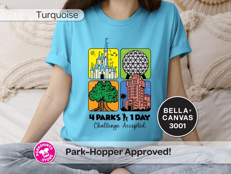 Puede incluir: Camiseta turquesa con un gr&aacute;fico colorido que presenta cuatro iconos de parques tem&aacute;ticos. El dise&ntilde;o incluye un castillo, una esfera geod&eacute;sica, un &aacute;rbol y un edificio alto. El texto dice "4 PARKS 1 DAY Challenge Accepted".