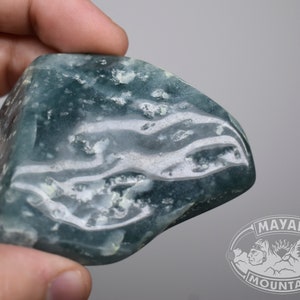 May include: A smooth, light blue and white agate stone with a swirling pattern. The stone is polished and has a translucent appearance.