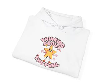May include: White hoodie with a pink and yellow cartoon star character wearing red shoes. The text "Thinking About The PWHL" is written in pink around the star.