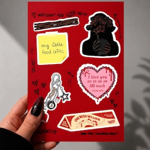 May include: A red sticker sheet featuring various illustrations including a yellow sticky note with the text 'my little food critic', a heart-shaped card with 'i love you so so so so SO much -freaky nikki', and a 'ONE WISH WILLOW' box graphic.