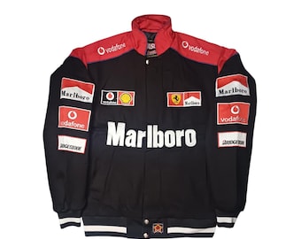 May include: Black and red racing jacket with the Marlboro logo across the chest. The jacket features multiple sponsor logos, including Vodafone and Bridgestone. The collar and shoulders are red, with white and black striped cuffs and hem.