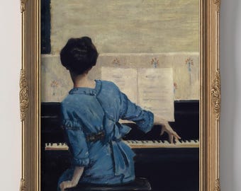 May include: A framed print of a woman playing a piano. The woman is wearing a blue dress and is seated at a black piano. The print is in a gold ornate frame and is mounted on a white wall.