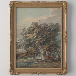 May include: A framed landscape painting featuring a large tree, a body of water, and horses. The artwork is set in a gold ornate frame. The painting has a vintage aesthetic with muted colors and a serene atmosphere.