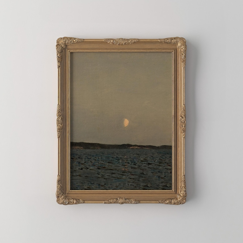 May include: A framed landscape painting depicts a serene seascape under a dusky sky. The artwork features a crescent moon, dark water, and a distant shoreline. The ornate gold frame adds a classic touch to the artwork.