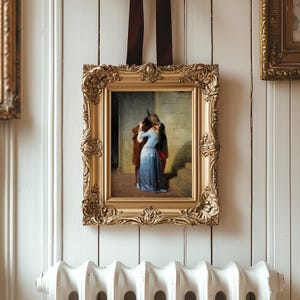 Pu&ograve; includere: Dipinto con cornice dorata ornata raffigurante una scena romantica di una coppia che si abbraccia. Il dipinto &egrave; appeso a una parete a pannelli bianchi con un radiatore bianco sottostante. La cornice ha dettagli intricati ed &egrave; sospesa da un nastro marrone.