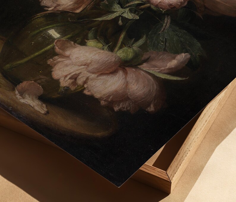 May include: A still life painting featuring soft pink peonies in a clear glass vase. The flowers are in full bloom, with delicate petals and green leaves. The painting is framed in a light wood frame.